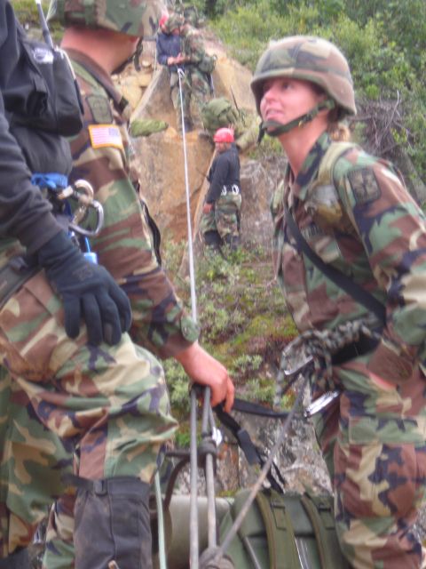 2003 Jeep TJ - Soldiers in camouflage uniforms are engaged in a rappelling exercise on a steep, rocky incline.