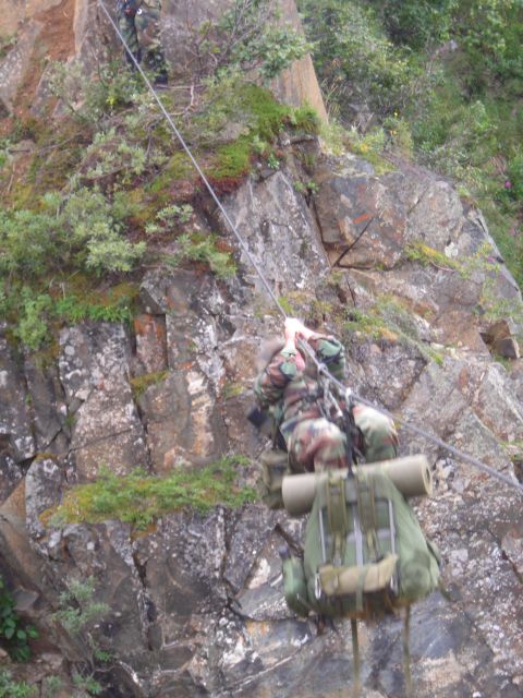 2003 Jeep TJ - Soldiers descend a cliff face using rappelling gear and ropes, carrying heavy backpacks.
