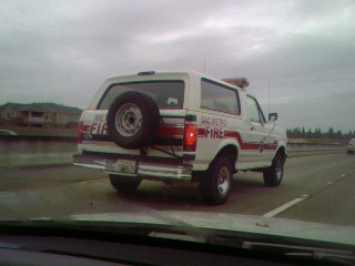 1989 Ford Bronco - White 1989 Ford Bronco SUV used by Sac Metro Fire department, seen from behind on a highway.