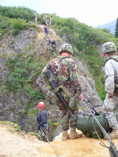2003 Jeep TJ - Military personnel conduct a challenging rappel down a , vegetated mountainside, demonstrating teamwork and specialized training.