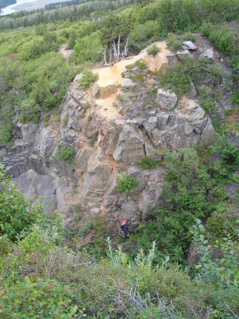 2003 Jeep TJ - A person is visible on a rocky cliff face, surrounded by dense vegetation.