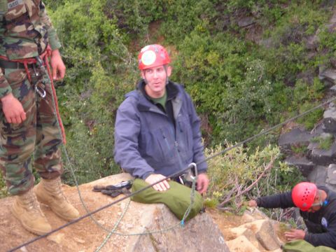 2003 Jeep TJ - Several individuals in climbing gear are positioned on a rocky cliff face, preparing for an ascent or descent.