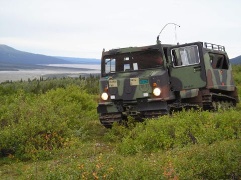 2003 Jeep TJ - An M113 Armored Personnel Carrier sits in a natural landscape, its tracks visible in the foreground.