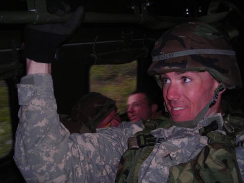 2003 Jeep TJ - Three soldiers are inside a vehicle, with one in the foreground looking towards the camera.