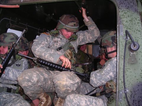2003 Jeep TJ - Soldiers are packed inside a military vehicle, preparing for deployment.