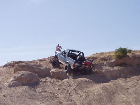 1993 Ford Bronco - Off-road Bronco navigates challenging terrain on a sunny day.