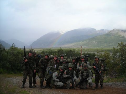 2003 Jeep TJ - A group of soldiers poses for a photo in a scenic mountain landscape under a cloudy sky with a rainbow.