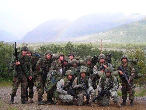 2003 Jeep TJ - A group of soldiers poses for a photo in a mountainous landscape, with a faint rainbow visible in the sky.