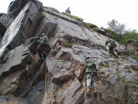 2003 Jeep TJ - Military personnel practice rappelling down a cliff, demonstrating their climbing and descent skills.