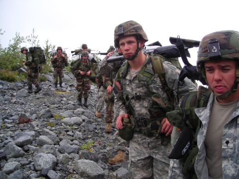 2003 Jeep TJ - Soldiers are seen marching in formation across a , rocky landscape.