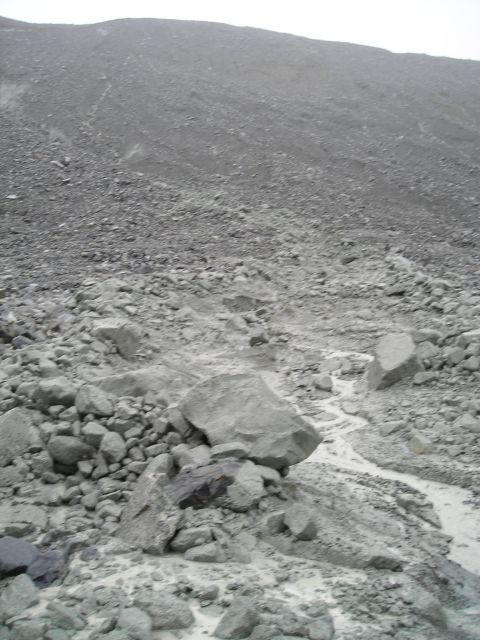 Rocky slope with a small stream flowing through debris