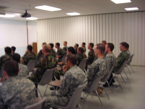 Classroom scene with soldiers seated and facing a projection screen