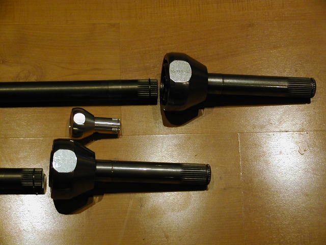 driveshafts and U-joints laid out on a wooden surface