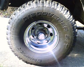 1979 Ford Bronco - A close-up view of a tire and wheel assembly, the Supermotors.net logo on the tire.