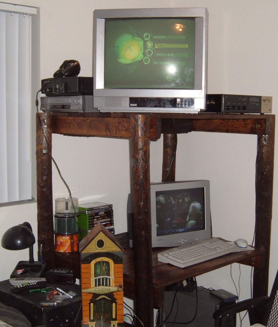 Wooden table with two televisions, a computer, VCR, and other electronics