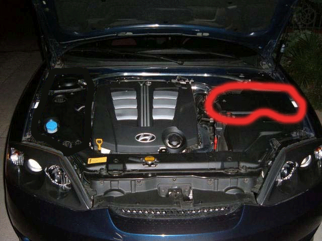 Open engine bay of dark blue Hyundai with red circle marking a plastic cover area