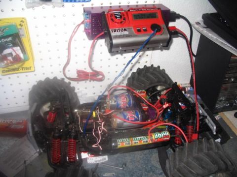 1986 Ford Bronco - The internal components of a remote-controlled monster truck are visible, connected to a battery charger.