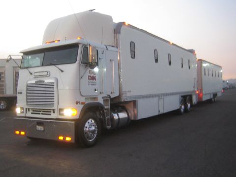 1990 Ford Bronco - white cabover semi truck with a chrome grille and KING KONG door lettering, hitched to sleeper trailers in a dim lot.