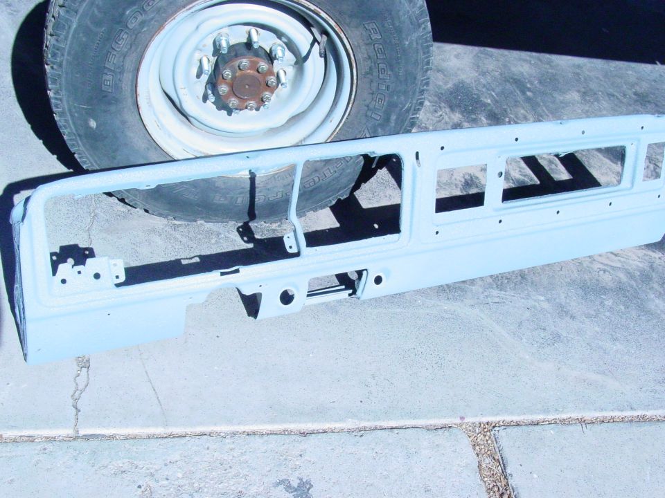 1978 Ford Bronco grille surround, light blue primer, with tire and wheel in background