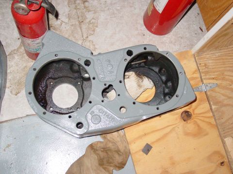1979 Ford Bronco - A gray painted engine component sits on a wooden surface, with fire extinguishers in the background.