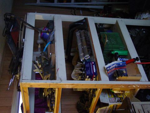 1979 Ford Bronco - A collection of automotive parts, possibly for a Ford Bronco, are organized in a storage rack.