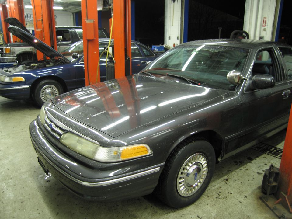 1991 Ford Crown Victoria LTD front view in a garage with another blue Crown Victoria in the background