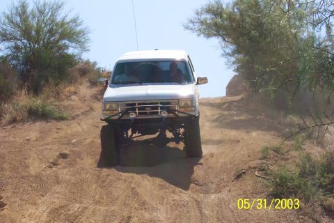 1993 Ford Bronco - 1993 Ford Bronco navigates a dirt trail with a brush guard installed.