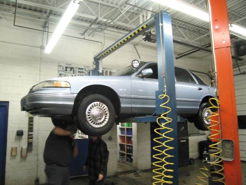 1991 Ford LTD Crown Victoria - A light blue 1991 Ford Crown Victoria LTD is shown on a car lift in a service bay.