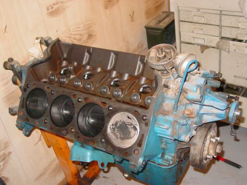 1979 Ford Bronco - Engine block assembly with distributor and visible cylinders, mounted on an orange engine stand.