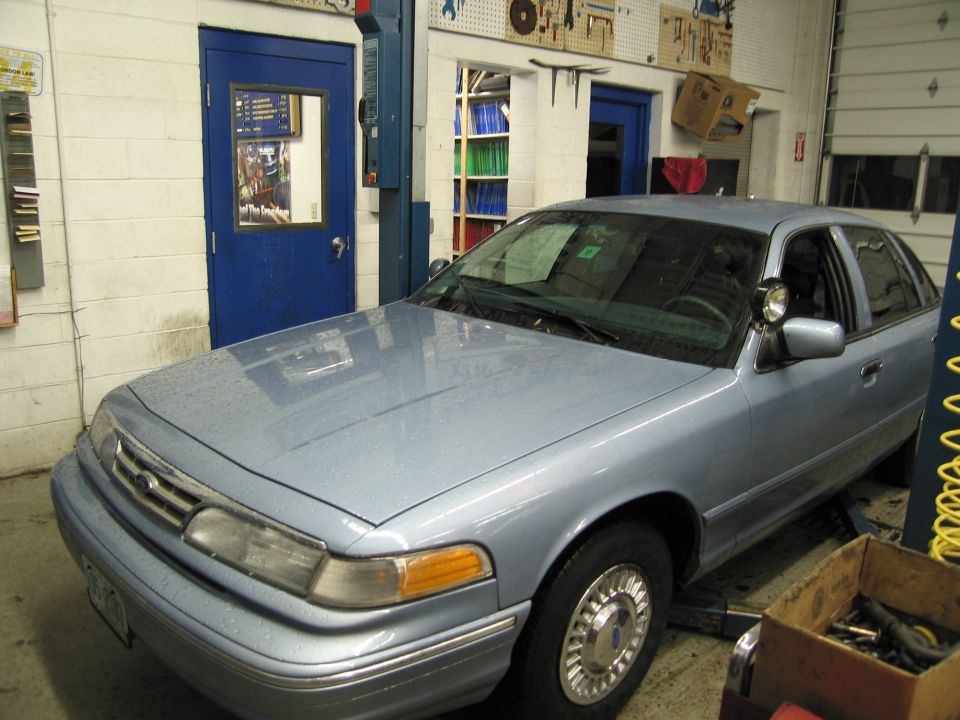 Light blue sedan with a chrome grille and hubcaps, parked in a garage