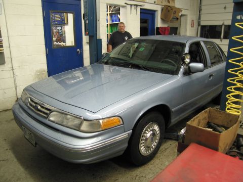 1991 Ford LTD Crown Victoria - A light blue 1991 Ford Crown Victoria LTD is parked inside a garage with a man standing behind it.