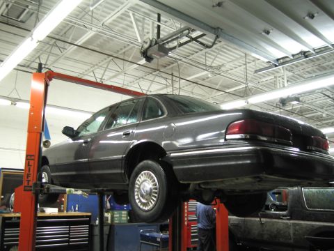1991 Ford LTD Crown Victoria - A 1991 Ford Crown Victoria LTD is raised on a car lift inside a service bay.