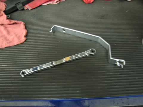 1991 Ford LTD Crown Victoria - Tools, including a ratchet wrench and a metal bracket, are laid out on a workbench.