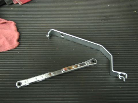 1991 Ford LTD Crown Victoria - Two metal automotive tools, possibly for engine or body work, are laid out on a workbench.