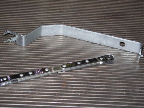 1991 Ford LTD Crown Victoria - A bent metal lever tool and a ratcheting wrench are shown on a ribbed surface.