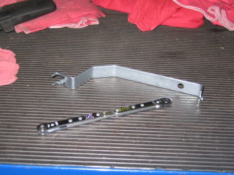 1991 Ford LTD Crown Victoria - A set of automotive trim removal tools, including a pry tool and a ratcheting wrench, are laid out on a textured surface.