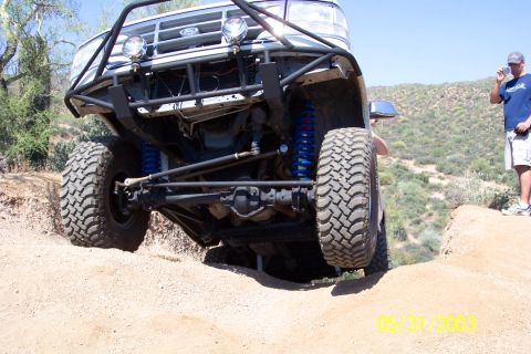1993 Ford Bronco - Off-road Bronco with custom suspension and roll cage navigates a steep incline.