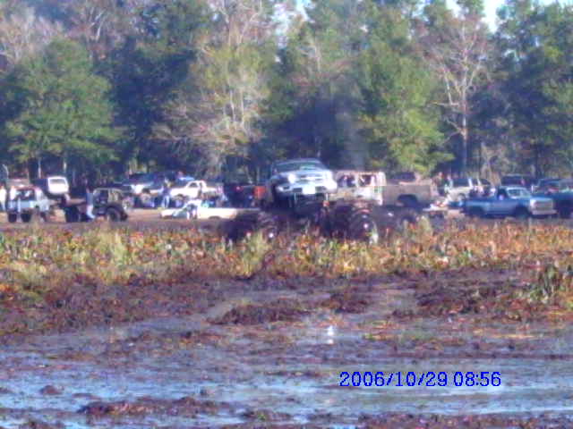 1987 Suzuki Samurai in mud, front view, with other vehicles and trees in background