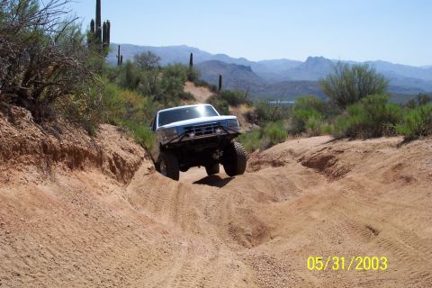 1993 Ford Bronco - This 1992 Ford Bronco navigates a challenging dirt path in a mountainous desert landscape.