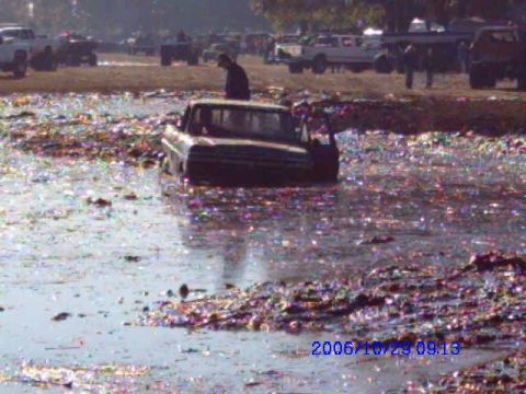 1987 Suzuki Samurai - A truck is stuck in a muddy, debris-filled area, with other vehicles visible in the background and a date stamp from 2006.