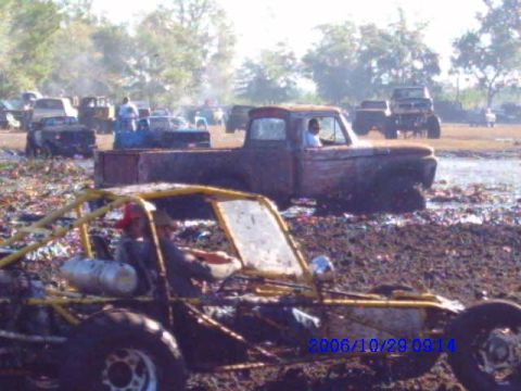 1987 Suzuki Samurai - Buggy and pickup truck stuck in mud at an off-road event.