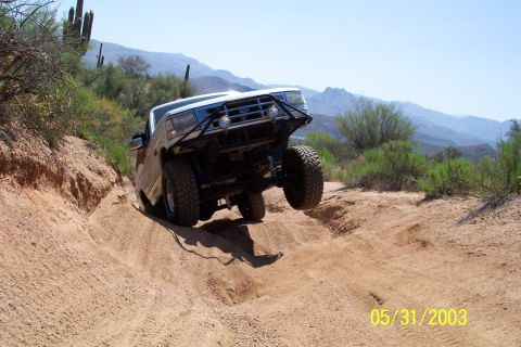 1993 Ford Bronco - This 1992 Ford Bronco is navigating a challenging off-road trail in a desert landscape.