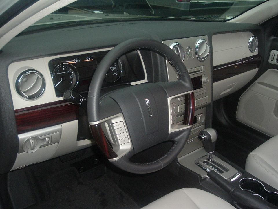 Lincoln sedan interior with steering wheel, chrome-ringed gauges and gray leather