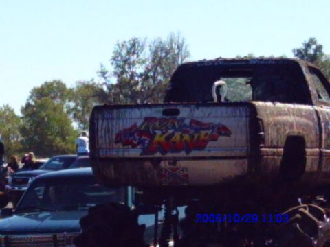 1987 Suzuki Samurai - A heavily muddied truck with custom graffiti on its tailgate is seen at an outdoor event.