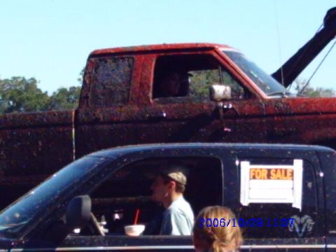1987 Suzuki Samurai - Two pickup trucks, one red with a tow boom and another black with a "FOR SALE" sign, are visible in this outdoor scene.