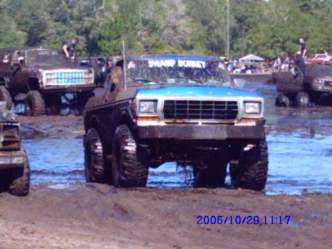 1987 Suzuki Samurai - Several heavily modified trucks are stuck in the mud at an off-road event.