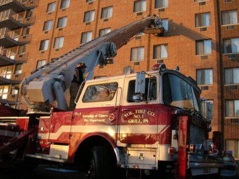 1989 Ford Bronco - Fire truck with its ladder extended towards a building, with text indicating it belongs to VOL. FIRE CO. NO. 1 GRILL, PA.