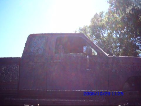 1987 Suzuki Samurai - This pickup truck is heavily covered in mud, obscuring its make and model.