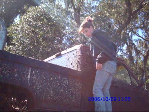 1987 Suzuki Samurai - A person stands beside a heavily mud-covered truck bed, suggesting off-road use.