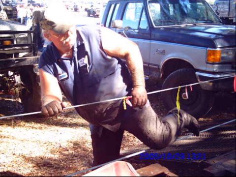 1987 Suzuki Samurai - A man is working on a vehicle, with a Ford truck in the background.